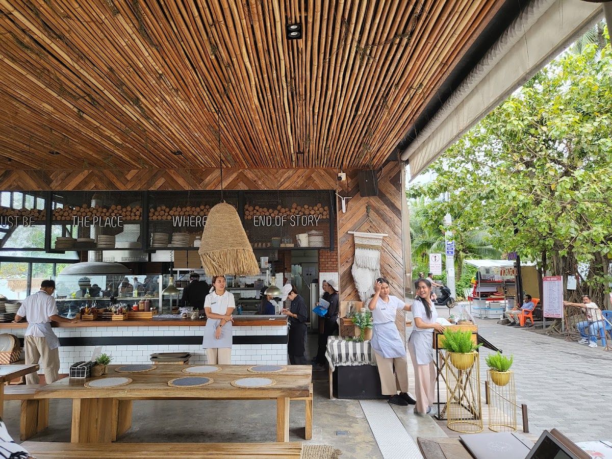 Open-air restaurant at Bophut Beach, Koh Samui — bamboo ceiling, timber details, and kitchen visible behind a counter, with staff preparing tables
