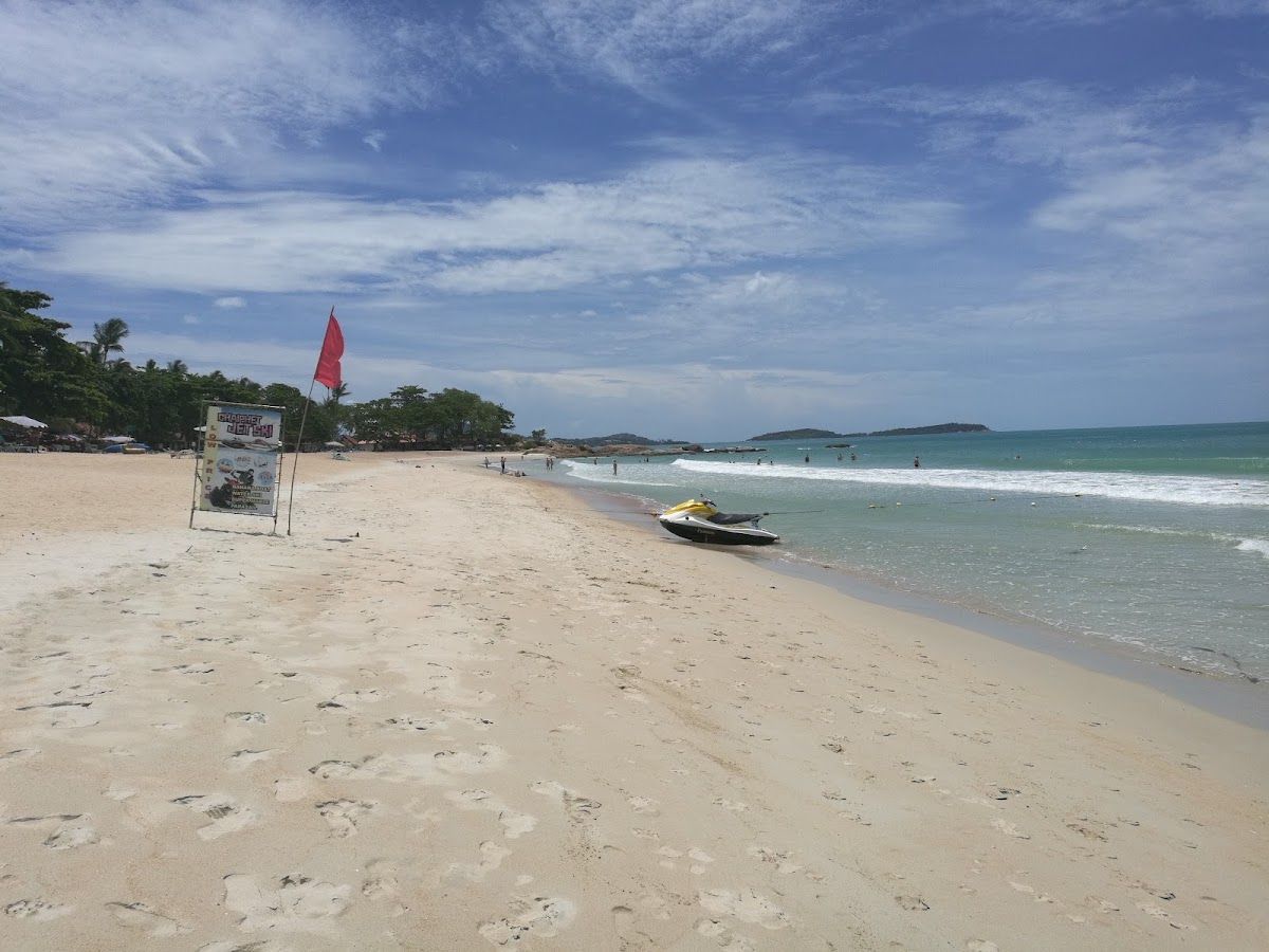 Chaweng Noi: same sand as central Chaweng, but the bar strip noise doesn't carry this far south Chaweng Noi Beach, Koh Samui — a quieter southern cove with white sand, clear water and lush hillside, away from the main Chaweng strip