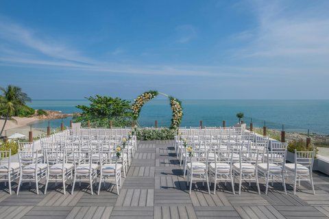Ritz-Carlton Koh Samui — cliffside pool villa with private infinity pool overlooking the Gulf of Thailand, tropical palms and rocky coastline in the foreground