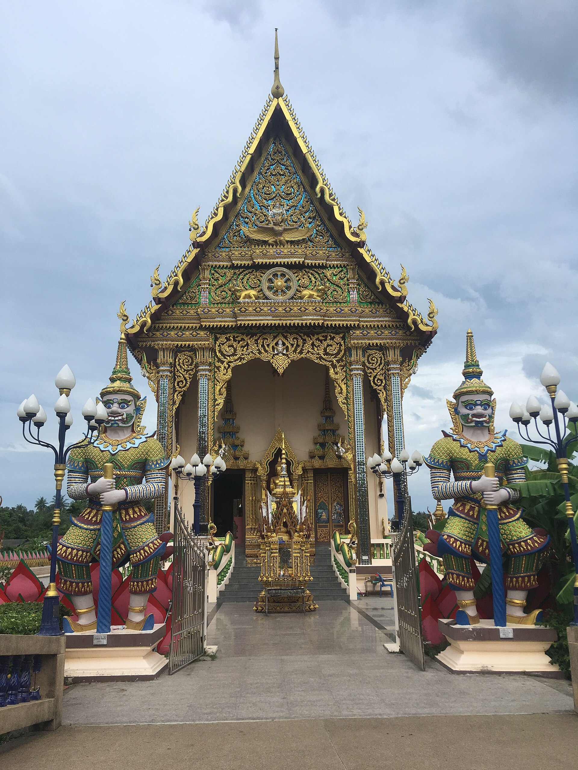 Ornate temple gate at Wat Plai Laem, with a multi-tiered roof and a carved arch
