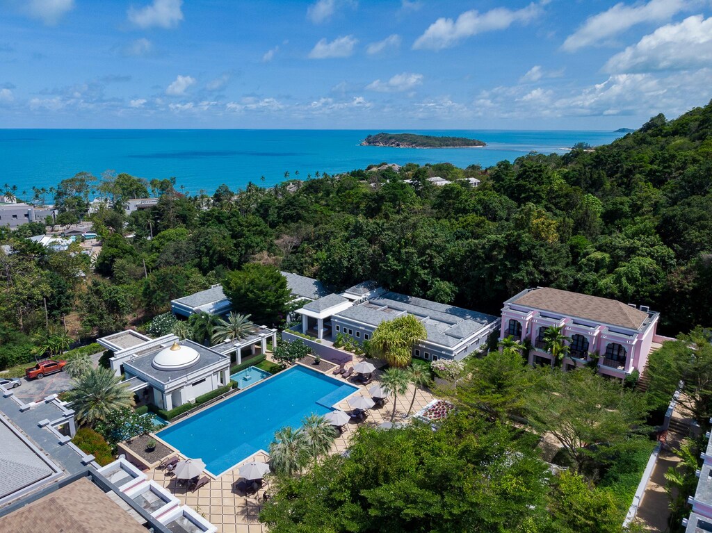 White resort buildings on the hillside at Absolute Sanctuary, with the sea in the distance