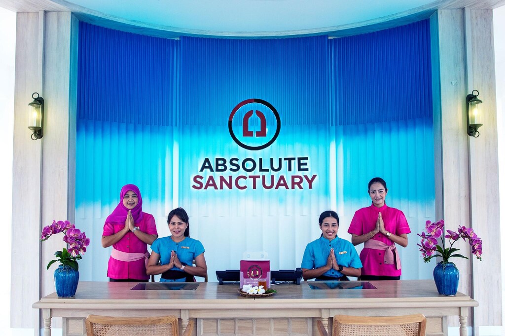Reception desk at Absolute Sanctuary, with a wooden counter and white walls