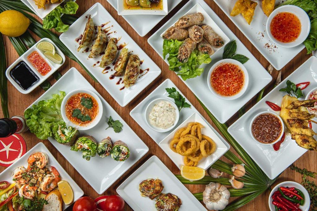 Plated dishes and drinks on a wooden table at Beach Republic