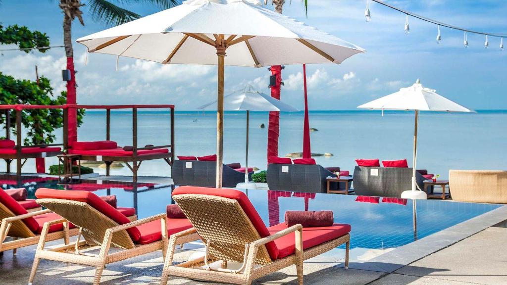 Beach Republic infinity pool with white daybeds, wooden parasols and the Gulf of Thailand beyond