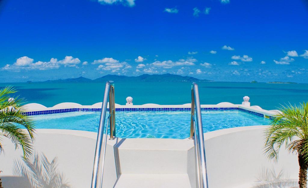 Outdoor pool on an upper deck at Hacienda Fisherman's Village, with sun loungers and the gulf beyond the palms